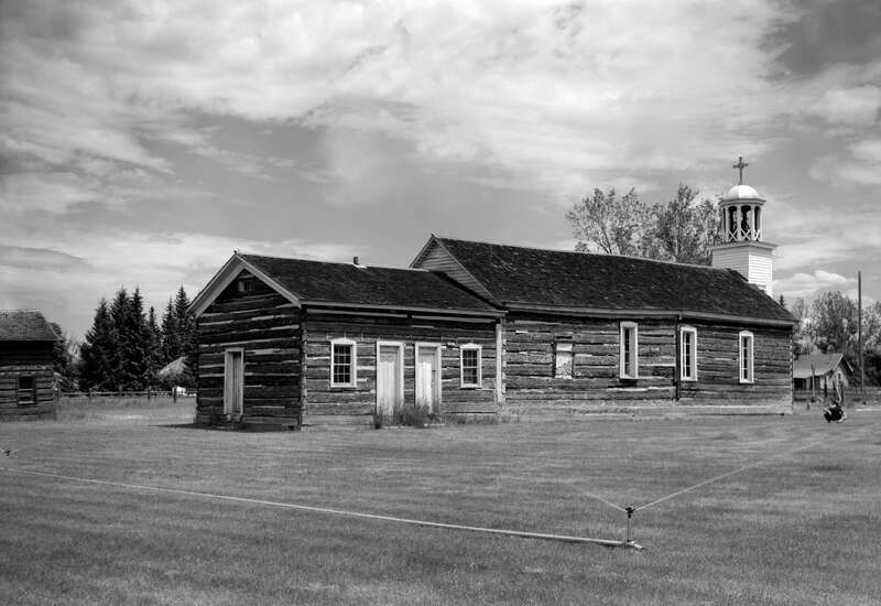 Southwestern view of St. Mary's Roman Catholic Mission, located along North Avenue in Stevensville, Ravalli County, Montana, United States.  Together with the attached pharmacy, visible on the far left, the church (built in 1866) is listed on the