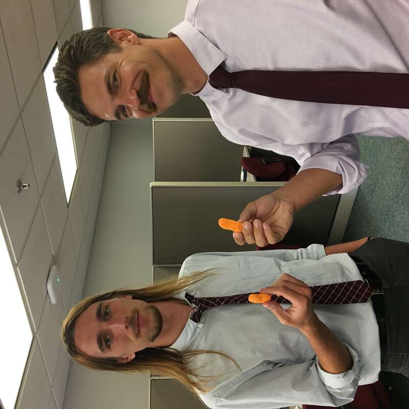 Two academics celebrate a dissertation proposal defense with circus peanuts