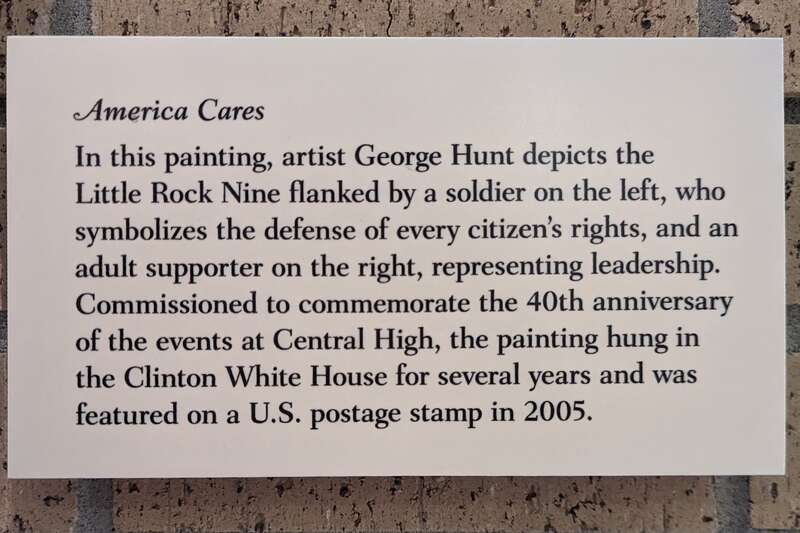 This is a photograph of the descriptive plaque on display next to &quot;America Cares,&quot; a painting of the Little Rock Nine, by George Hunt. It hangs in the visitor center of the Central High School National Historic Site.