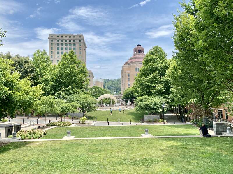 On the left, built in 1924-1928, this Classical Revival-style building was designed by Frank Pierce Milburn to serve as the Buncombe County Courthouse, replacing a previous courthouse that stood immediately in front of the present building, which was