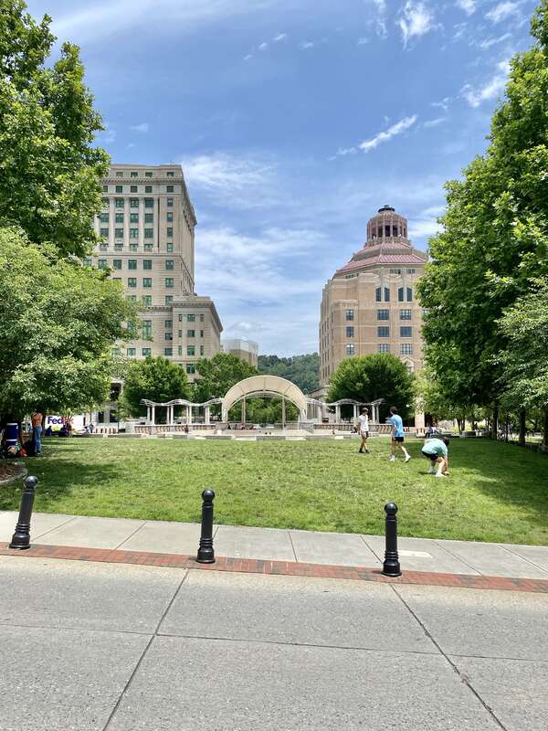 On the left, built in 1924-1928, this Classical Revival-style building was designed by Frank Pierce Milburn to serve as the Buncombe County Courthouse, replacing a previous courthouse that stood immediately in front of the present building, which was