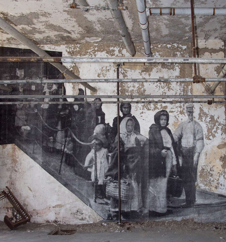 The Ellis Island Immigrant Hospital, closed since 1930. The photograph is one from the early 20th century, when the hospital was operational. In 2014 the French artist JR put up large reproductions of such photographs around the hospital grounds.