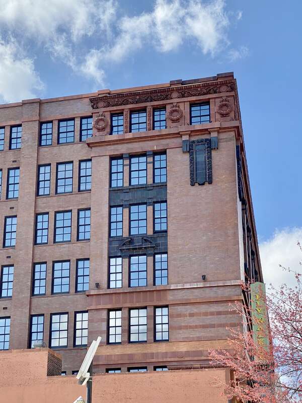 Built in 1906, this Beaux Arts-style building was designed by Eames and Young for the Ely and Walker Dry Goods Company.  The building features a red brick exterior with orange and black terra cotta trim, one-over-one double-hung windows, rusticated