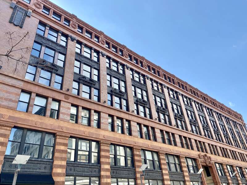 Built in 1906, this Beaux Arts-style building was designed by Eames and Young for the Ely and Walker Dry Goods Company.  The building features a red brick exterior with orange and black terra cotta trim, one-over-one double-hung windows, rusticated