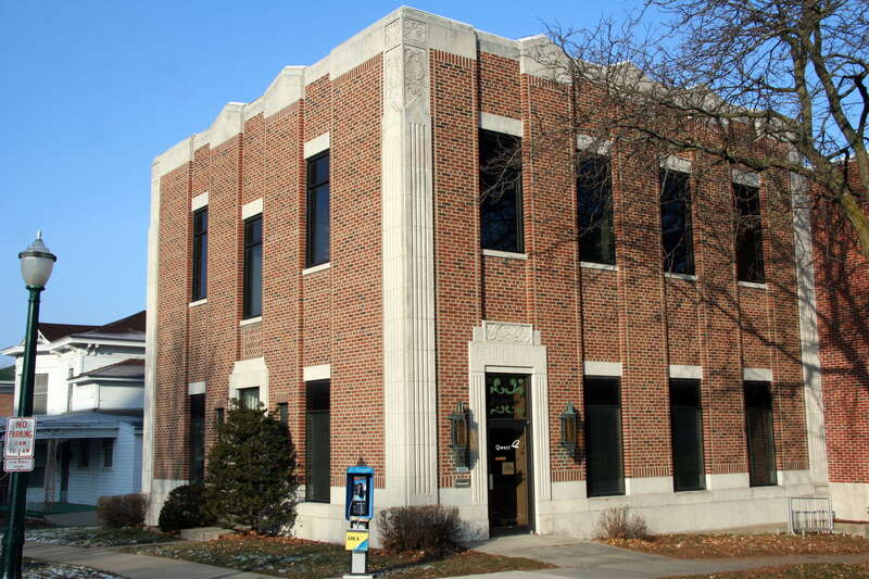 Qwest telephone exchange building on the corner of Main and Court Streets in Decorah, Iowa, with a public phone in front and the Norwegian word &quot;Velkommen&quot; painted above the door.