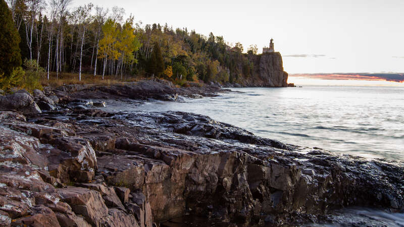 A picture of the majestic lighthouse trying the capture the colors of the  tree leaves of that are still up there withstanding the forces of wind, this place can get quite windy.