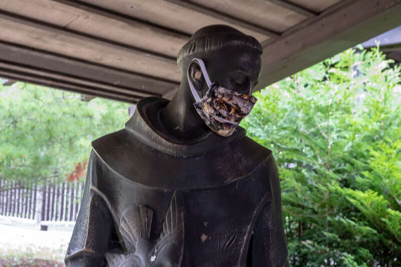 Covid-19 Pandemic mask on garden statue