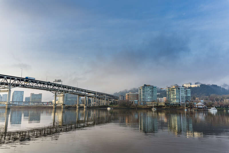 Sunrise (behind the photographer) in Portland, Oregon, in the early winter of 2016.  To the left of the Marquam Bridge is the South Waterfront District, and to the right of the bridge is the RiverPlace district.  Marquam Hill is in the background.
