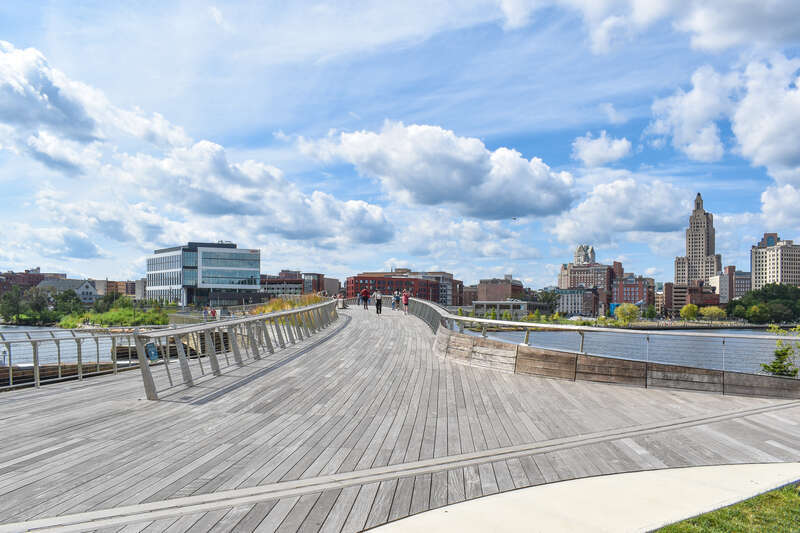 A northwest facing view from the eastern terminus of the Michael S. Van Leesten Memorial Bridge in Providence, Rhode Island. In the distance, the Jewelry District is visible to the left while the skyline of Downtown Providence is visible to the