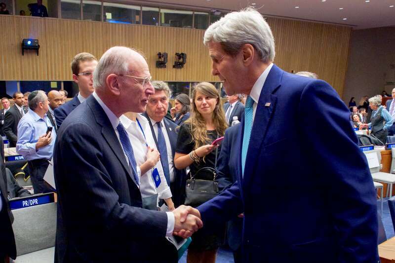 U.S. Secretary of State John Kerry greets former U.S. diplomat Stuart Eizenstat before delivering remarks at the “Battle for Zionism at the U.N.: Marking 40 Years Since the Historic Speech of President Chaim Herzog,” on November 11, 2015, at the