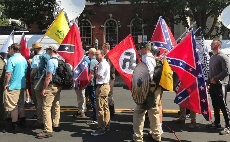 Alt-right members preparing to enter Emancipation Park holding Nazi, Confederate, and Gadsden &quot;Don't Tread on Me&quot; flags.