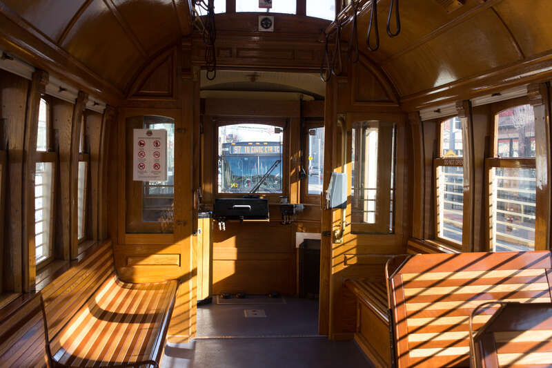 Interior of a Loop Trolley car in service, while westbound on Delmar Blvd. east of Kingsland Avenue in University City, Missouri (in the St. Louis metropolitan area), being followed by a bus on MetroBus route 97.  This is looking towards the rear of