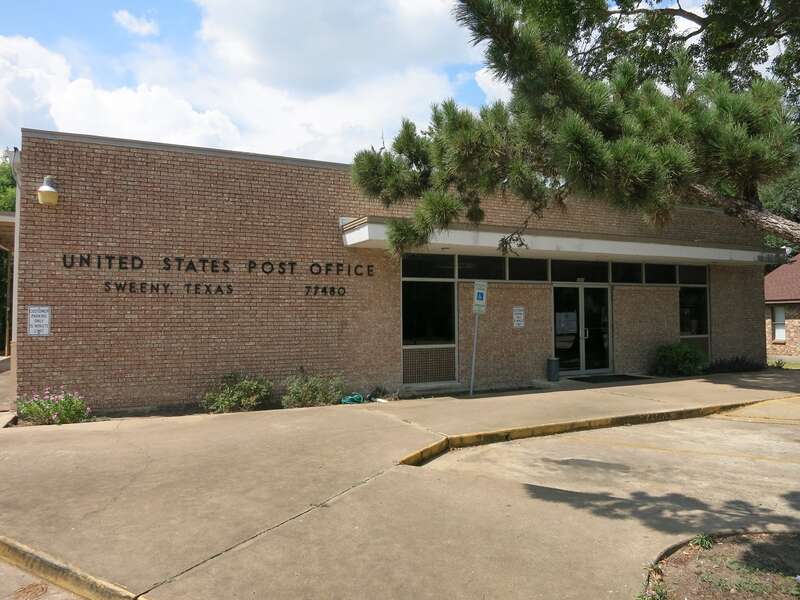 Photo shows the US Post Office at 301 E 2nd St, Sweeny, TX 77480. View is toward the north.