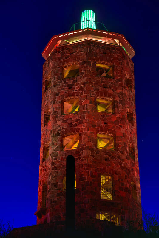 The Enger Observation Tower in Enger Park, Duluth, as it appears at night, footlit by floodlights.