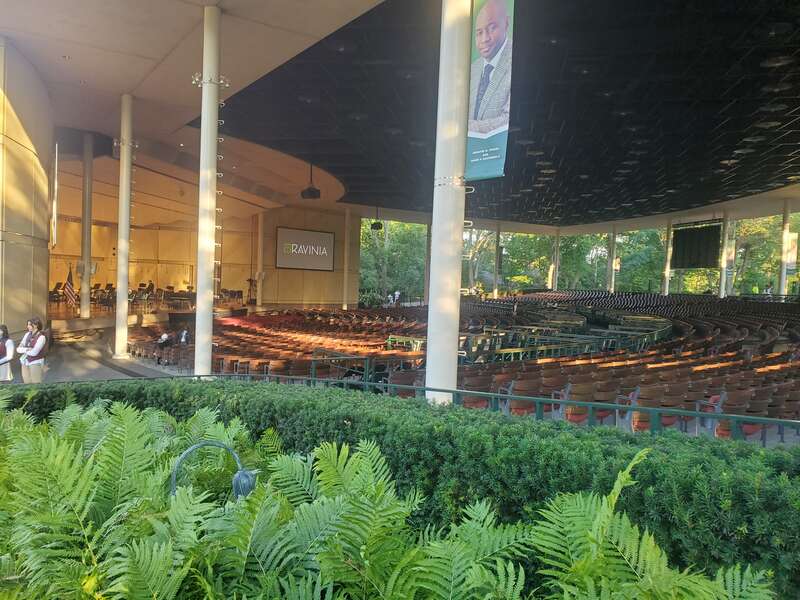 Photo has the pavilion section seats, the TV showing the performance, and stage to the left.