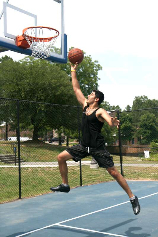 A young man leaps toward the goal at a basketball court on Anderson Street next to the Devil's Bistro in Durham, North Carolina.