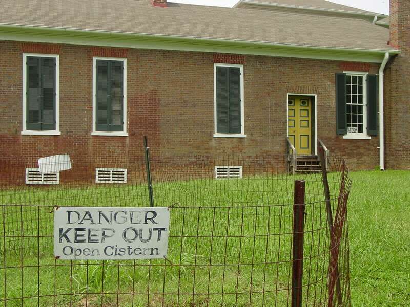 Side view of Belle Mont house with fence around cistern