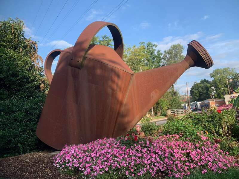 Staunton Virginia Historical Watering Can. Made by Willy Ferguson in 1999, a giant rusty watering can and flower pots on both sides of a railroad overpass. Heading into the downtown part of Staunton.