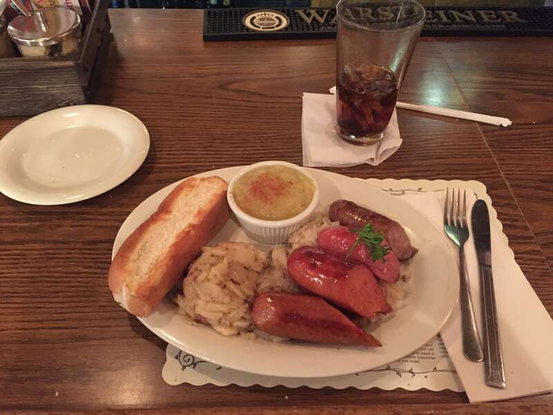 Dish with four different sausages, potato salad, apple puree, and a bread roll in Schmidt's Sausage Haus in Columbus, Ohio