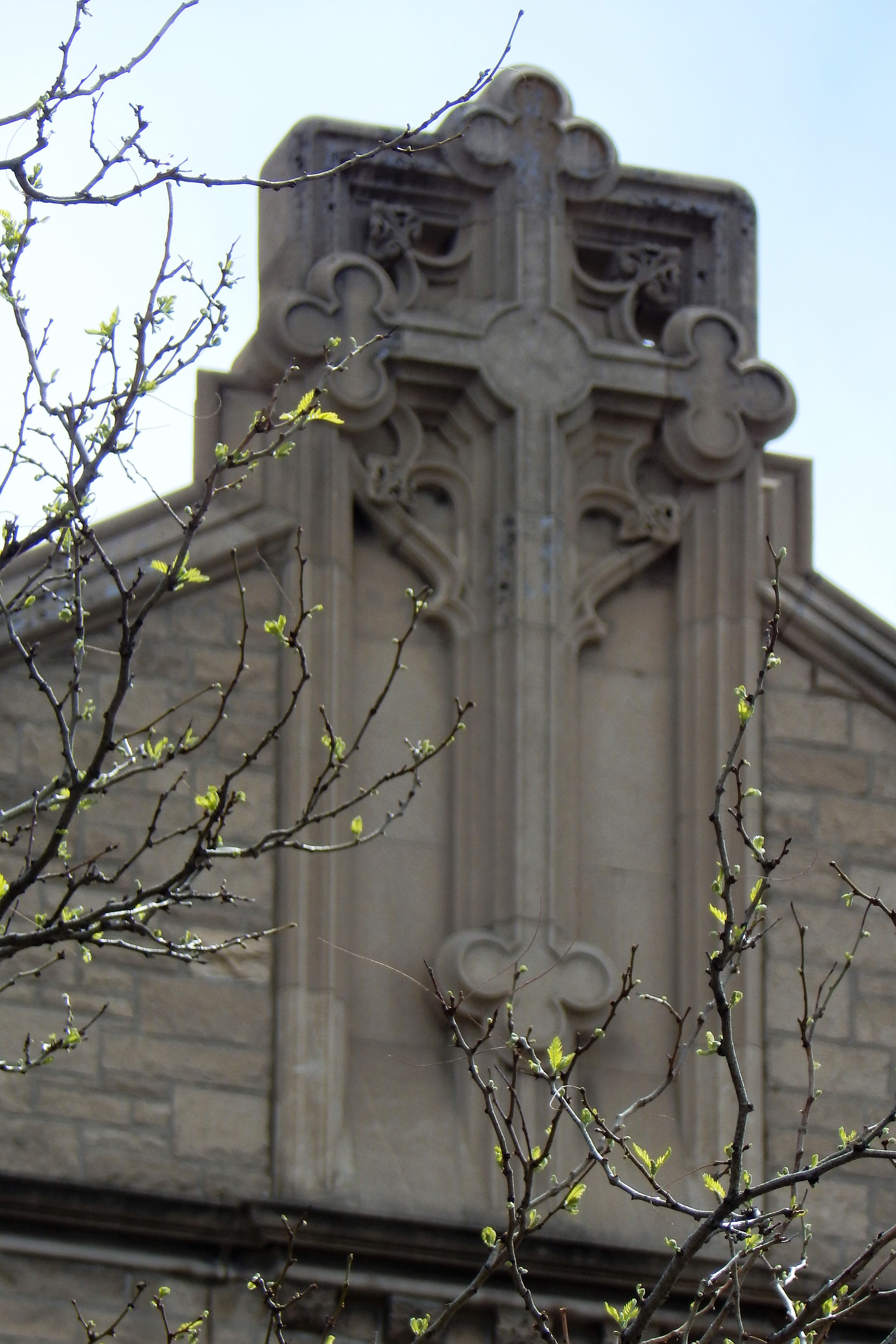 A clover-leaf cross stands high over the north facade of the Cathedral.