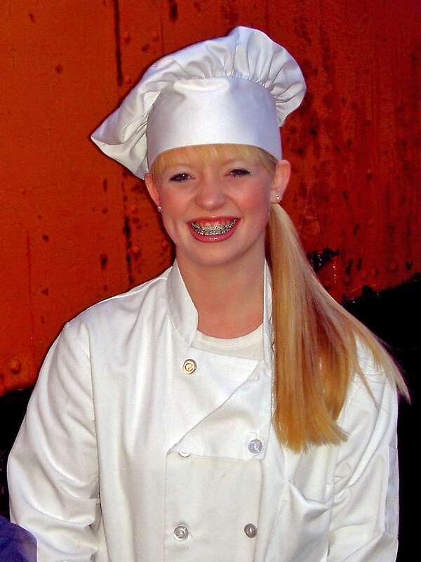 Young woman wearing a traditional chef's uniform