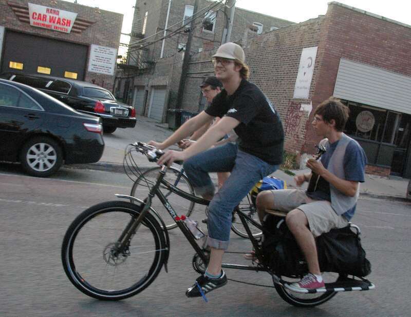 Rider plays ukuele.  At 2744 N. Southport Ave., Chicago, facing west-northwest.  Selected images by Andrew Ciscel's flickr bicycling photostream set. Chicago Critical Mass