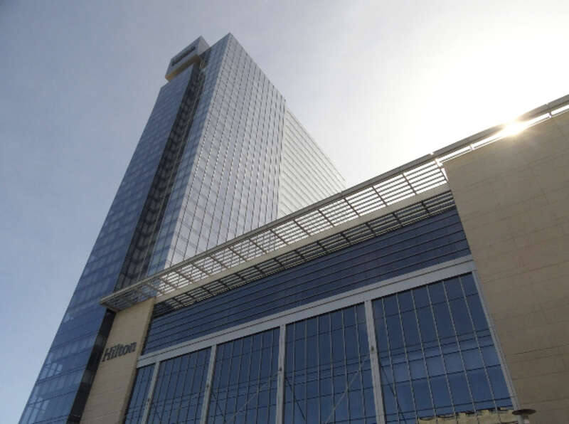 The glassy, modern Hilton Cleveland Downtown [Convention Center] Hotel (HCDH) on a bright, warm day; perspective looking up from Ontario Street and Lakeside Avenue in downtown Cleveland, Ohio.