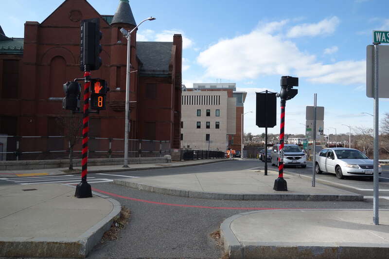 Standing on the triangle traffic island at the center of the intersection of Washington Street and Bridge Street at the north end of downtown Salem, Massachusetts. Note that the crosswalks are at street level.