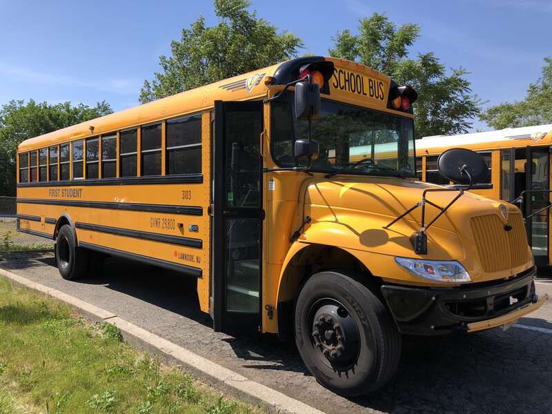 Front passenger-side view of a First Student school bus at a bus depot in East Orange, Essex County, New Jersey