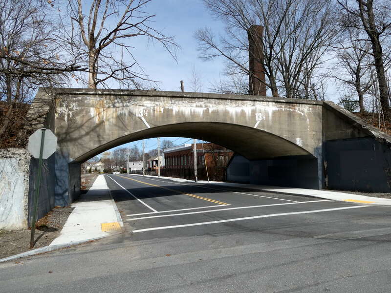 Arch bridge carrying the Fitchburg Secondary over Greeley Street in downtown Clinton, Massachusetts, in March 2022