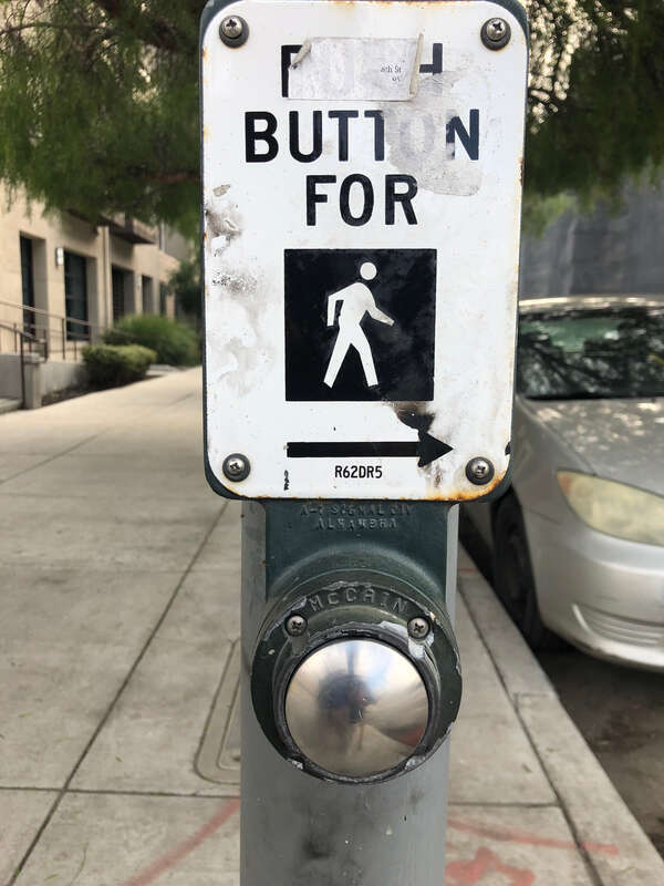 The pedestrian call button to cross North 7th Street at eastbound East Taylor Street in San Jose, California.