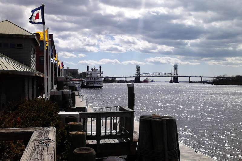 The Cape Fear River as seen from the Wilmington Riverwalk with the Cape Fear Memorial Bridge in the distance.