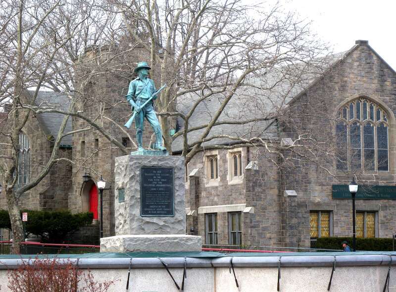 Looking northeast at statue and Community Church of the Circle in Mt Vernon on a cloudy afternoon