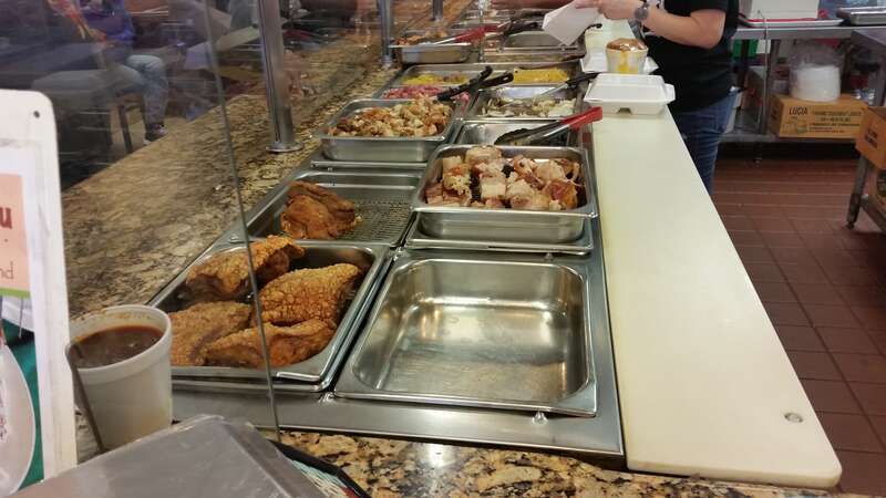 A steam table at Jochi Resto Grill with various Filipino dishes