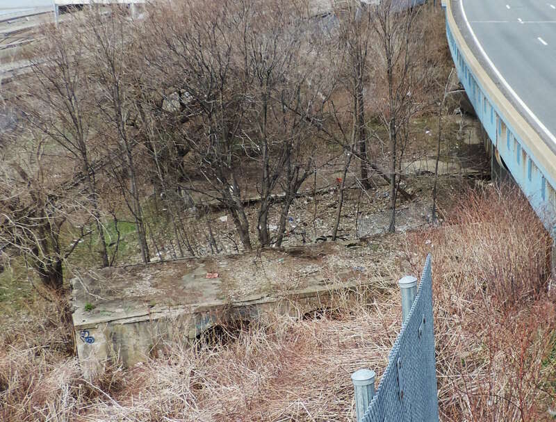 Looking north and down at platforms of abandoned Sedgwick Avenue station on a cloudy afternoon.