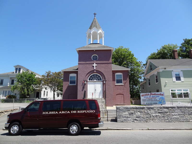 Iglesia Arca de Refugio, a Hispanic Pentecostal church located at 60 Lawrence Street, Lowell, Massachusetts.  West (front) side of building shown, with a church bus visible in the foreground.