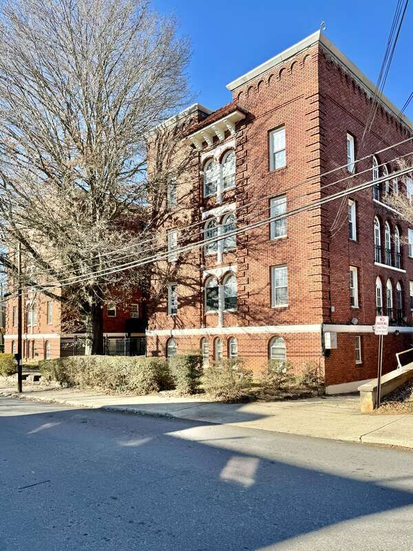 Built in 1923, this Romanesque Revival-style building was designed by Ronald Greene to serve as the Jefferson Apartments.  The building features a red brick exterior with four-over-four, six-over-six, and eight-over-eight double-hung windows, arched