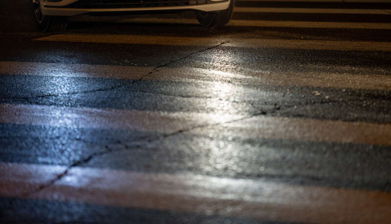 A vehicle passes the crosswalk making a left turn at Lyndale Avenue South and West 28th Street in Minneapolis, Minnesota, at night.