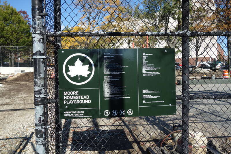 A modern NYC Parks sign at the entrance to the playing courts at the south end of Clement Clarke Moore Homestead Playground, on 45th Avenue between Broadway and 82nd Street in Elmhurst, Queens. The entire park is undergoing a major reconstruction
