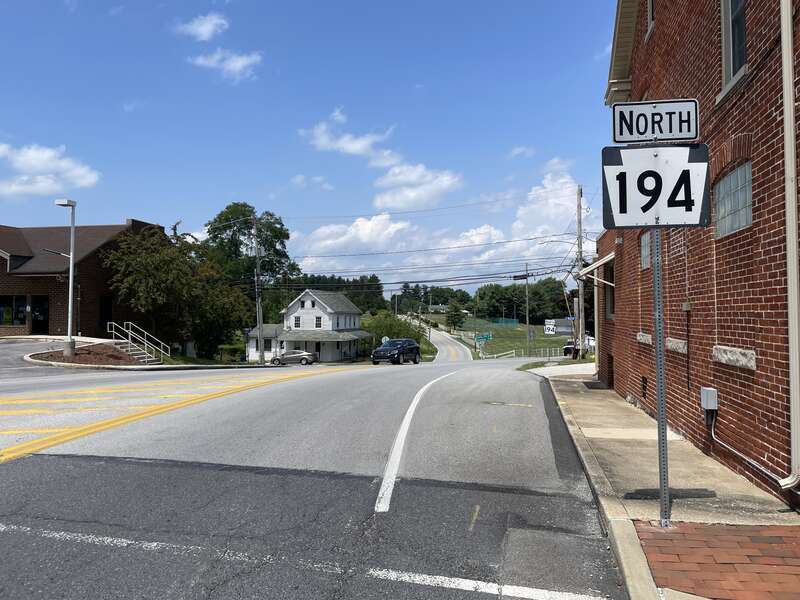 Northbound Pennsylvania Route 194 (Queen Street) past the traffic circle with U.S. Route 30 (King Street) in Abbottstown, Pennsylvania