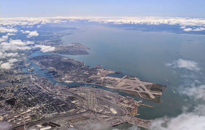 Aerial view from the northeast of the Port of Oakland and Alameda Island, Calfornia, with the old Alameda Naval Air Station runways prominent