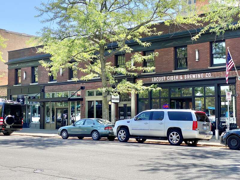 Built in 1927, this Classical Revival-style building was built by Henry Rombeck to serve as a rooming house on the upper floors, with retail spaces on the ground floor.  The building features a red wire brick exterior with eight-over-one double-hung