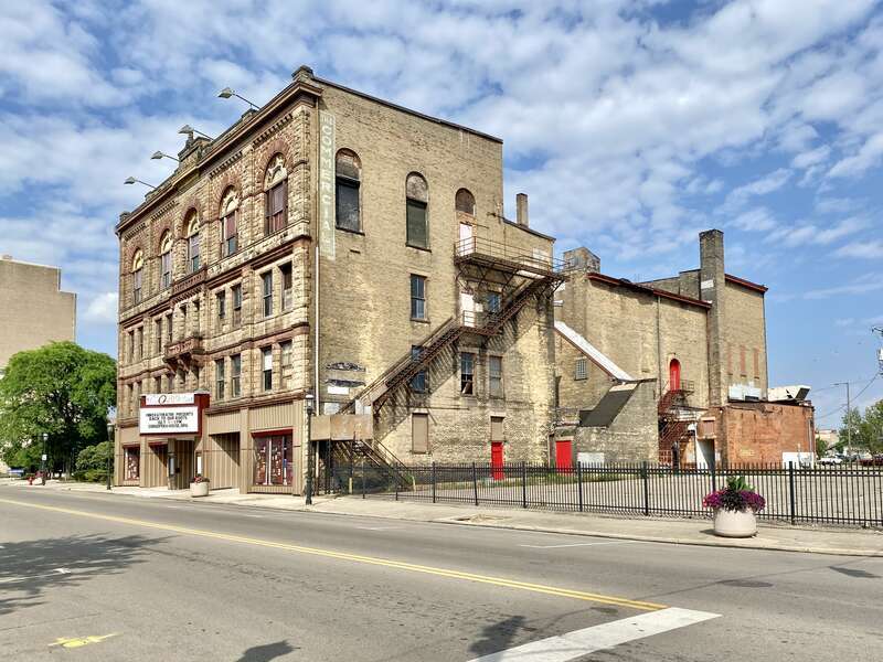 Built in 1890, this Richardsonian Romanesque Revival-style building was designed by Samuel Hannaford for Paul J. Sorg to serve as an opera house.  The building features a brick exterior with a rough-hewn stone front facade, arched window bays on the