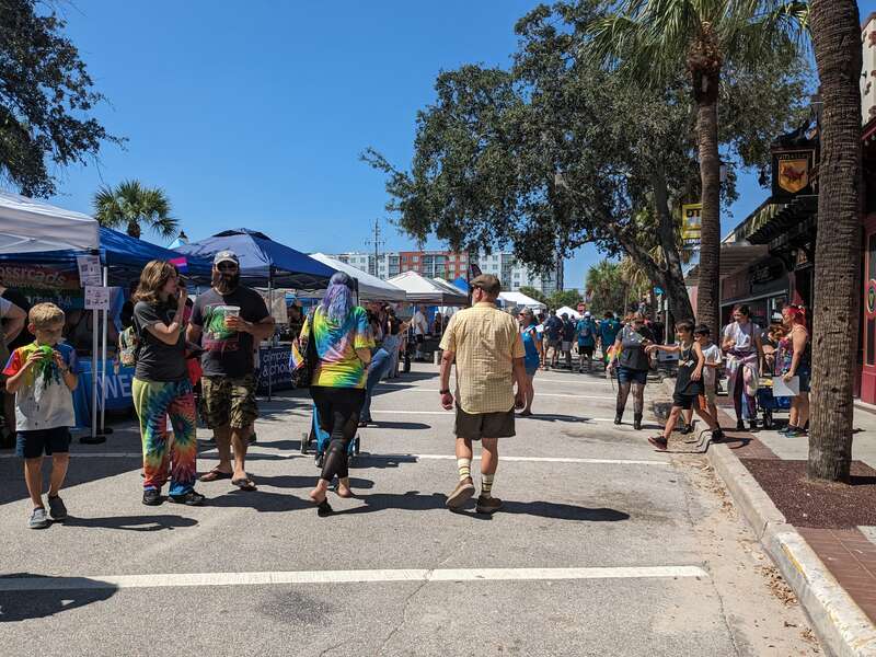 Families and other attendees walking alongside tents