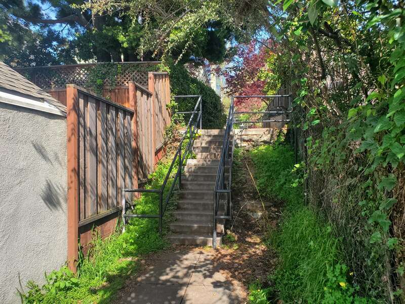Stairs on the Holly Park footpath between York Drive and Ricardo Avenue in Piedmont, seen in March 2024. From 1924 to 1958, the footpath was used to access the Holly Park stop on the Piedmont line (later the C Line) of the Key System. Trains stopped