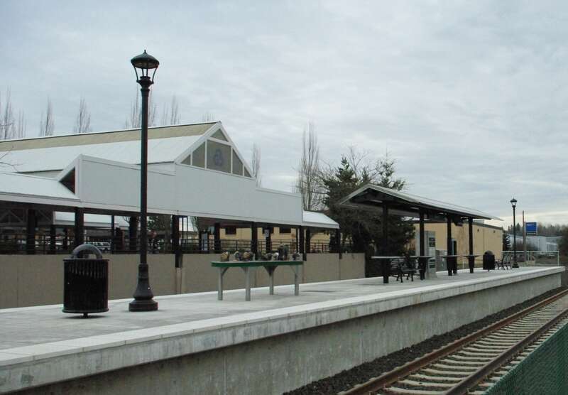 The Tigard Transit Center commuter-rail station, in downtown Tigard, Oregon, with the transit center's 1988-opened bus portion in the background.