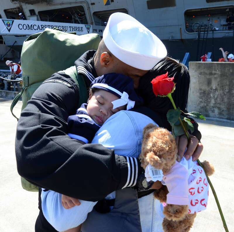 A sailor stationed aboard the aircraft carrier USS John C. Stennis hugs his wife and daughter on the pier during their homecoming to Naval Station Kitsap in Bremerton, Wash. John C. Stennis is returning from an eight-month deployment to the U.S. 5th