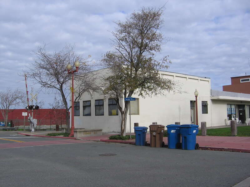 Building at 1-99 I Street in Antioch, California.  This older, vaguely art-deco styled building sits adjacent to the former AT&amp;amp;SF tracks in Antioch.  A gate arm for the I Street grade crossing is visible to the left of the building, which sits