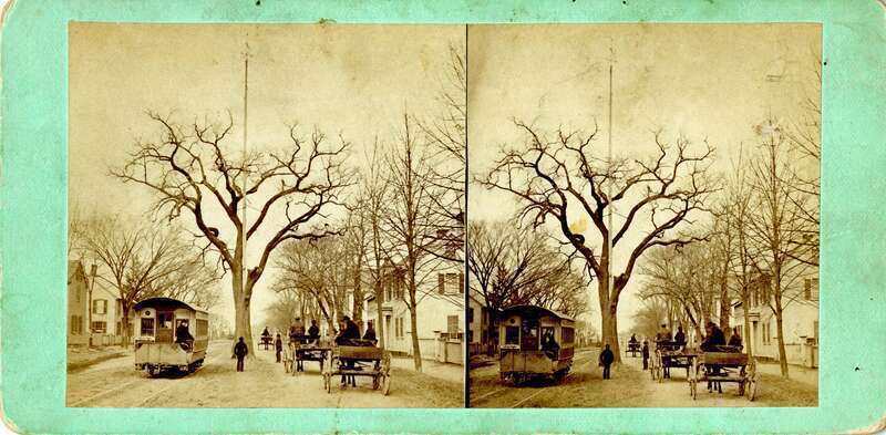 SV-049 — Nelson Dionne Collection. View of the Big Tree in the center of Boston Street, near the modern location of the AOH building; the house to the far-right is extant today as 106 Boston St. The tree is flanked on the left by a trolley, and the