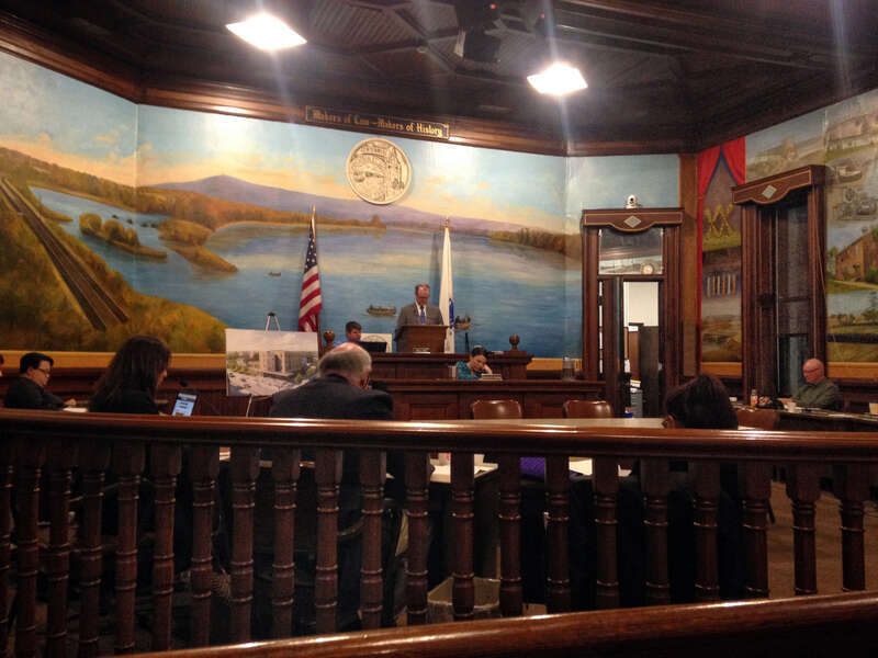 The City Council Chambers, formerly known as the Aldermanic Chambers (still seen in some signage and documents), on the first floor of Holyoke City Hall. The hall prominently features a mural of the Log Pond and Connecticut River, with Mount Tom in